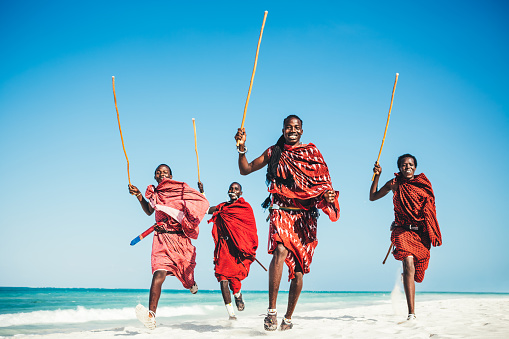 Masai warriors running on beautiful african beach, demonstrating their traditional hunting methods (zanzibar, Tanzania)