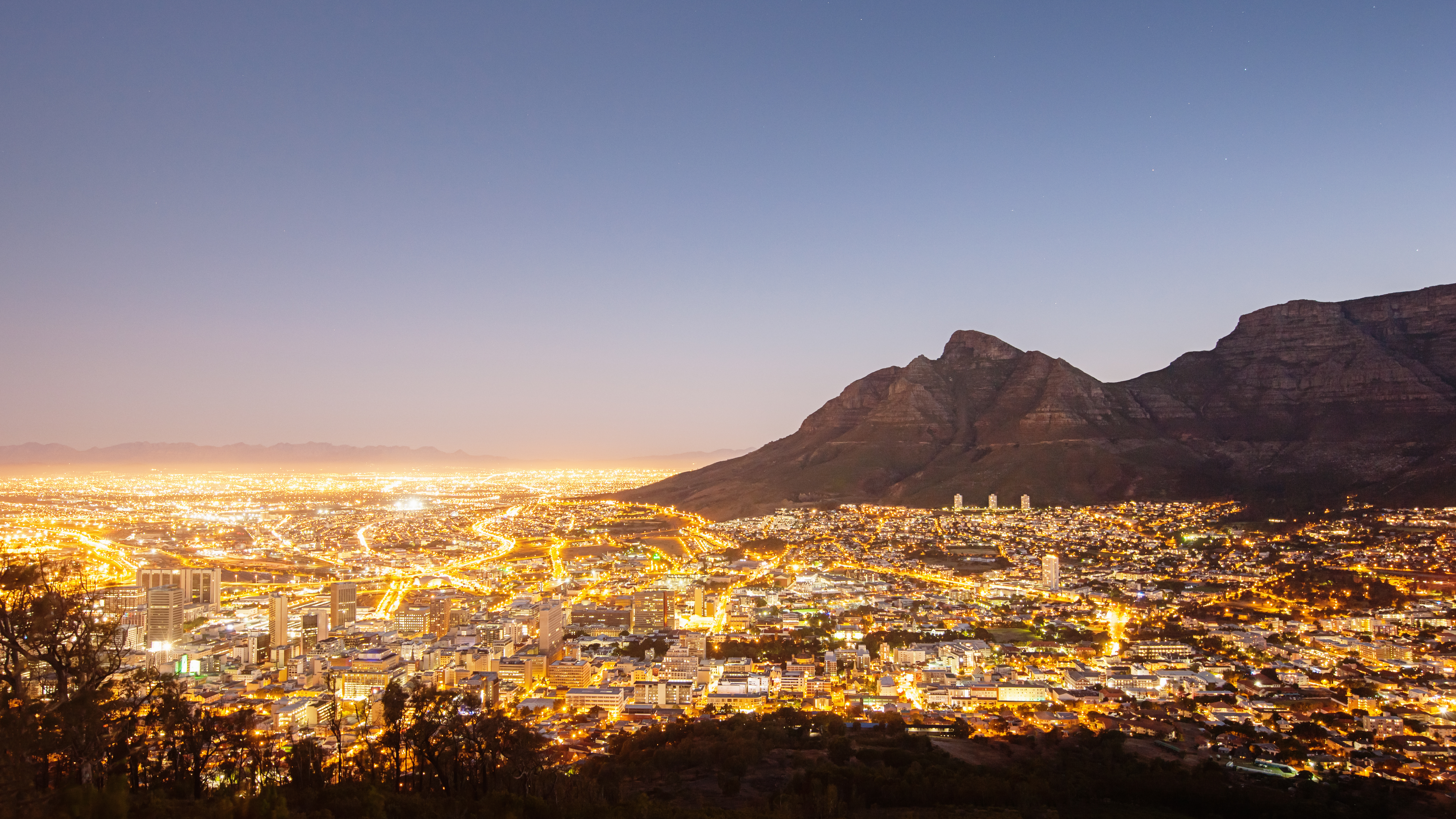 Panorama view over illuminated Cape Town Cityscape at the foot of famous Table Mountain under clear sky. Cape Town, South Africa.