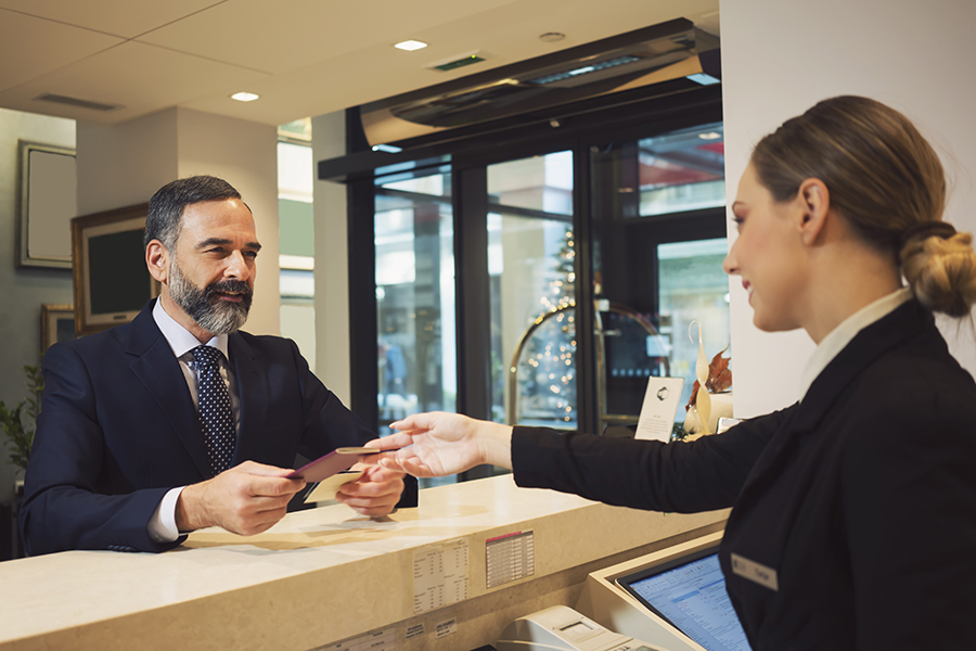 Business man at reception desk with receptionist