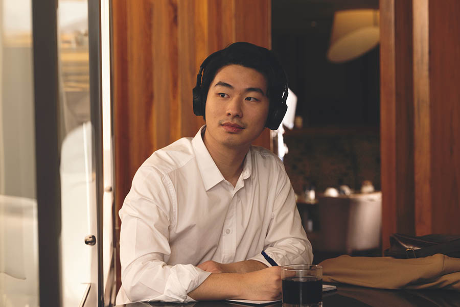 A person wearing headphones and sitting at a desk.