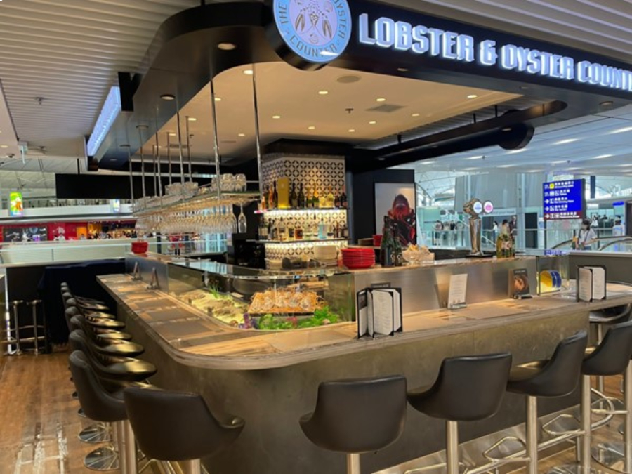 Indulge in delectable seafood at Caviar House & Prunier, an airport bar in Hong Kong, serving lobster and oysters.